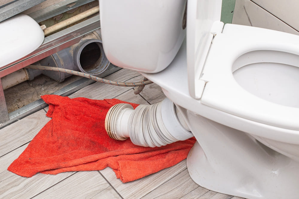 Toilettes démontées avec tuyau de raccordement déconnecté lors d'une intervention de débouchage