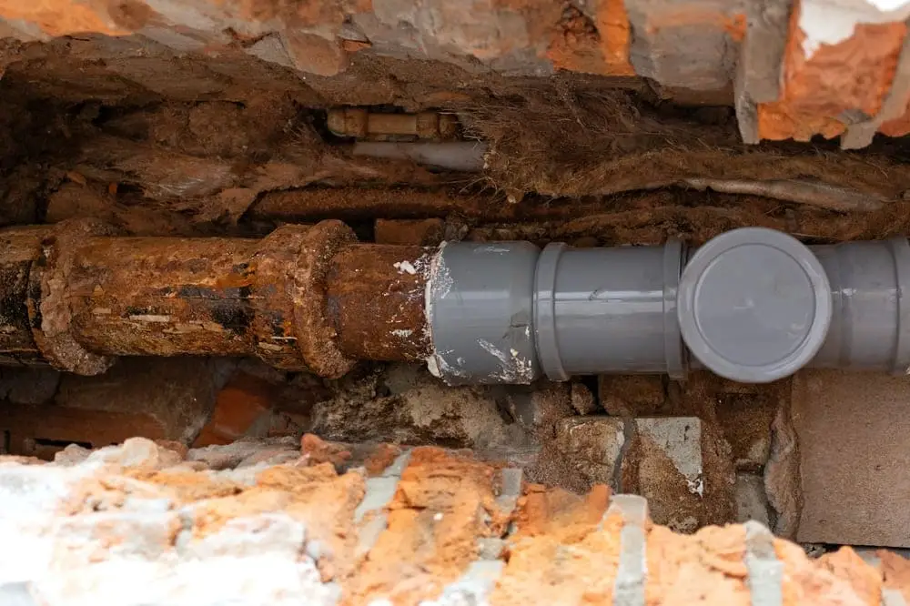 Débouchage Mouscron : Réparation de canalisation d'égout. Remplacement partiel de l'ancien tuyau en fonte par un nouveau tuyau en plastique.