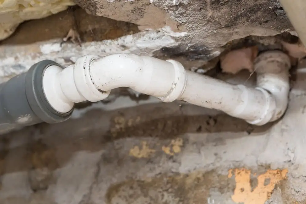 Débouchage Uccle : Tuyaux d'égout dans le sous-sol d'une maison. Système de tuyaux sanitaires gris dans une vieille maison.