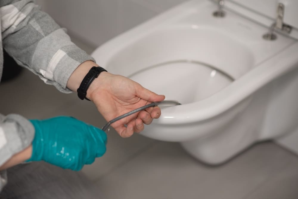 un professionnel effectuant un débouchage WC Watermael-Boitsfort Bruxelles-Capitale